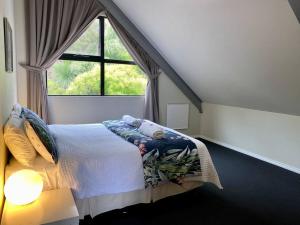 a bedroom with a bed and a large window at Carnaby's Hide in Albany