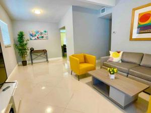 a living room with a couch and a yellow chair at Executive House Miami, Close to Airport, Beach in Miami