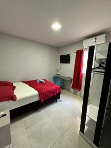- une chambre avec un lit et une couverture rouge dans l'établissement Casa de 2 Quartos no Centro, à Marabá