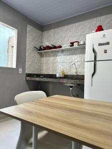 una cucina con tavolo e frigorifero bianco di Casa de 2 Quartos no Centro a Marabá