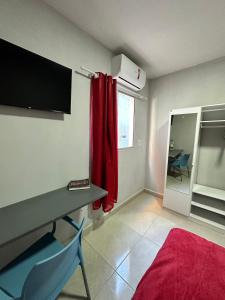 Cette chambre comprend un rideau rouge, un bureau et une fenêtre. dans l'établissement Casa de 2 Quartos no Centro, à Marabá