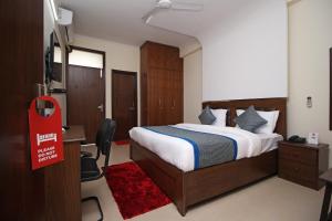 a bedroom with a bed and a desk and a red sign at OYO Surya Palace in New Delhi