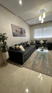 烏季達的住宿－Haut Standing Appartement - Centre Ville Oujda，客厅配有沙发和桌子