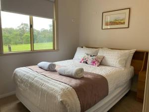 ein Schlafzimmer mit einem Bett mit zwei Kissen und einem Fenster in der Unterkunft Settlers Chalet in Kalgan
