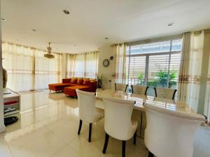 uma sala de jantar com uma mesa e cadeiras e um sofá em Chomdao house98 em Udon Thani