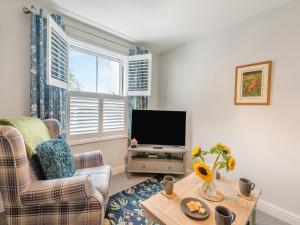 a living room with a television and a table at Elwell Cottage in Beverley