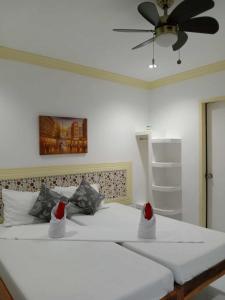 um quarto com uma grande cama branca com chapéus de Pai Natal em Bountiful Inn em Puerto Princesa