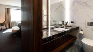 a bathroom with a sink and a toilet at Horizon by SkyCity in Auckland