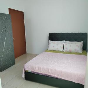 斗湖的住宿－Ummik Homestay，一间卧室配有一张带黑色床头板和枕头的床。