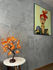 a table with a plant and a painting on the wall at SOLAR DI LUCCA Lindo Apartamento com piscina in Londrina