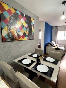 een eetkamer met een tafel met stoelen en een schilderij bij SOLAR DI LUCCA Lindo Apartamento com piscina in Londrina