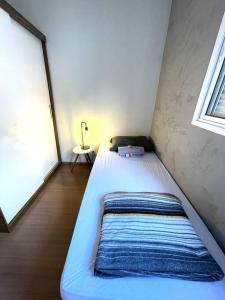 een bed in een kleine kamer met een raam bij SOLAR DI LUCCA Lindo Apartamento com piscina in Londrina
