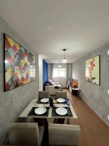 een eetkamer met een tafel en stoelen en een woonkamer bij SOLAR DI LUCCA Lindo Apartamento com piscina in Londrina