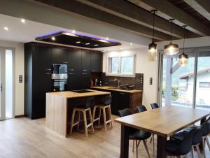 a kitchen with a wooden table and a dining room at Superbe Chalet Neuf in Cornimont