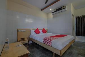 a bedroom with a large bed with red pillows at OYO Mayur's Residency Near Malkpet in Surūrnagar