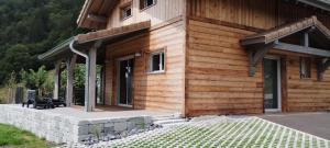 une cabane en rondins avec une terrasse couverte et un banc extérieur dans l'établissement Superbe Chalet Neuf, à Cornimont