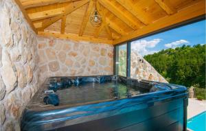einen Whirlpool in einem Steingebäude mit einem großen Fenster in der Unterkunft Villa Sansation in Imotski