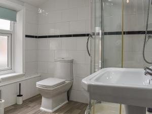a white bathroom with a toilet and a sink at Lavender House in Barnoldswick