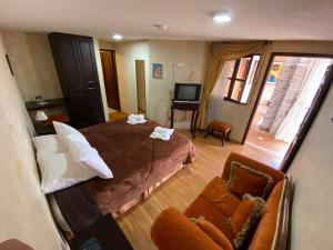a room with a bed and a couch and a television at Golden Rest Ecuador in Latacunga