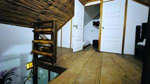 Hostal Kaia في سانتا مارتا: غرفة مع أرضية خشبية وسلم خشبي