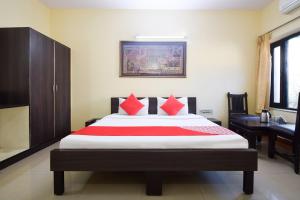 um quarto com uma cama grande e almofadas vermelhas em OYO 24408 Nirmala Guest House em Jodhpur