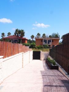 a walkway leading to a house with a fence at Casa en l'Ampolla, patio y bbq, cerca de la playa. in L'Ampolla