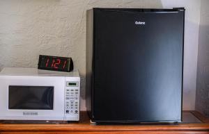 a microwave and a clock on a wooden table at Cypress Fairway Village in Wimberley