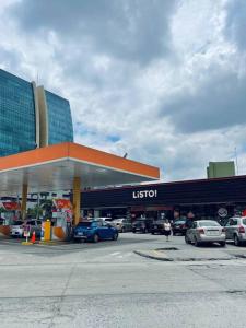 um posto de gasolina com carros estacionados num parque de estacionamento em Cómoda Suite cerca de todo em Guayaquil