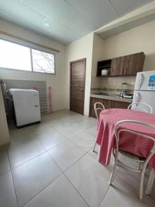 a kitchen with a table and a refrigerator at Cómoda Suite cerca de todo in Guayaquil