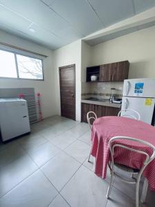 a kitchen with a table with a pink table cloth on it at Cómoda Suite cerca de todo in Guayaquil