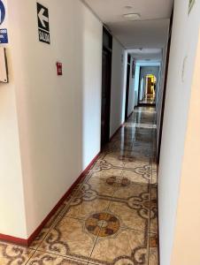un pasillo en un hotel con suelo de baldosa en Hostel Las Vegas en Lima