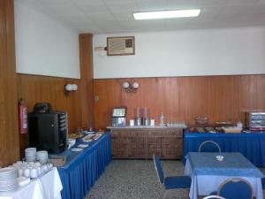 Habitación con cocina con mesas azules y barra. en Hotel Roca, en Vinarós