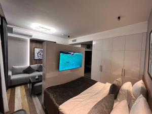 Schlafzimmer mit einem Bett und einem Flachbild-TV in der Unterkunft Tumanyan Apartments in Yerevan