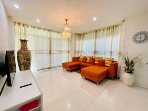 a living room with orange chairs and a couch at Chomdao house98 in Udon Thani