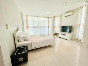 um quarto com uma cama e uma televisão de ecrã plano em Chomdao house98 em Udon Thani