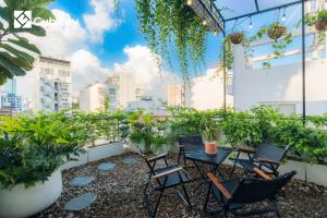 a rooftop patio with chairs and plants on a building at Cubicity Metro House in Ho Chi Minh City