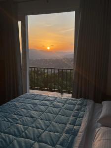 a bedroom with a bed and a view of the sunset at Golden sky in Kandy