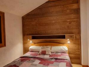 a bedroom with a bed with a wooden headboard at Appartement Valloire, 4 pièces, 12 personnes - FR-1-263-528 in Valloire