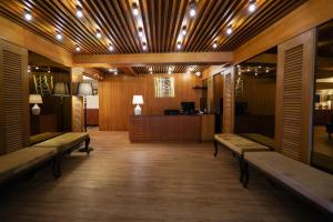 a lobby with benches and a desk in a room at The poshtel Bangkok By Benya BTS Phayathai in Bangkok