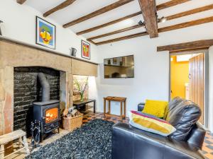 a living room with a fireplace and a couch at Manor House Cottage in Highpeak Junction