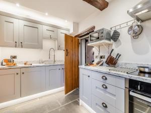 a kitchen with white cabinets and a stove at Manor House Cottage in Highpeak Junction