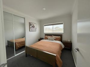 Dormitorio pequeño con cama y espejo en Surrey View, en Narrawong