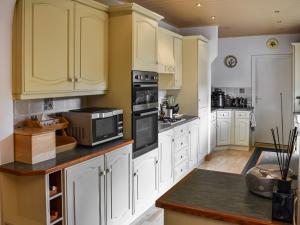 une cuisine avec des armoires jaunes et un comptoir dans l'établissement Wood Close, à Keswick
