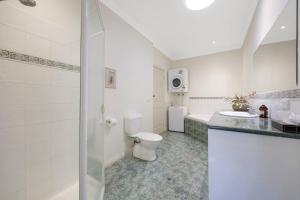 a bathroom with a toilet and a sink and a tub at One bedroom apartment in CBD in Warrnambool