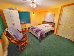 a bedroom with a bed and a chair and a window at Waterfront Cottage for rent (Near Sauble Beach) in Wiarton