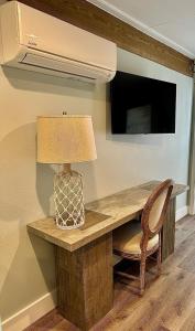 a table with a lamp and a chair and a television at Waterfront Guesthouse on Key Allegro/Little Bay with dock in Rockport
