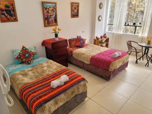 1 dormitorio con 2 camas, mesa y sillas en Cusco guest house, en Cusco