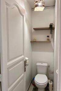 a bathroom with a white toilet and a door at L'Escale, appt partagé, shared apartment in Pointe-à-Pitre