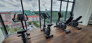 een fitnessruimte met diverse hometrainers voor een groot raam bij Lovely Kozi Square comfort Studio Home 2A in Kuching