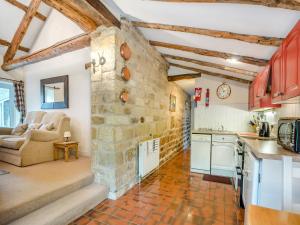 eine Küche und ein Wohnzimmer mit einer Steinmauer in der Unterkunft Bridge Cottage - W43184 in Hawnby